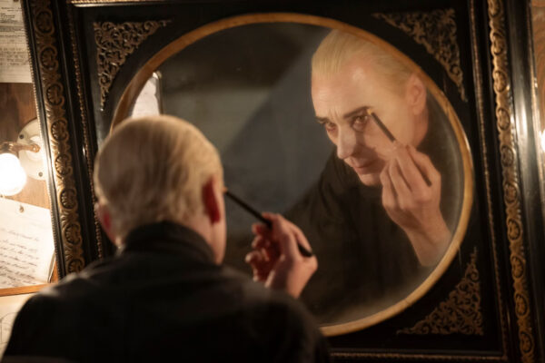 Santiago (Ben Daniels) applies eyeliner in the mirror