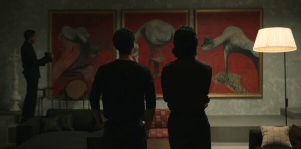 Louis (Jacob Anderson) and Armand (Assad Zaman) survey a piece of art with their backs to the camera