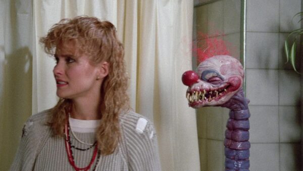 Debbie (Suzanne Snyder) is menaced by a bathroom tentacle Klown lurking behind her