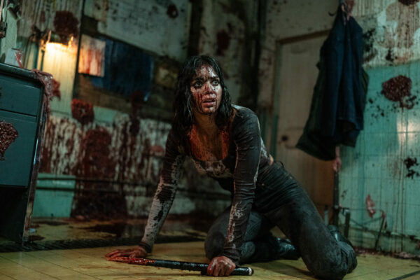 Melissa Barrera as Joey, crouched down and covered in blood