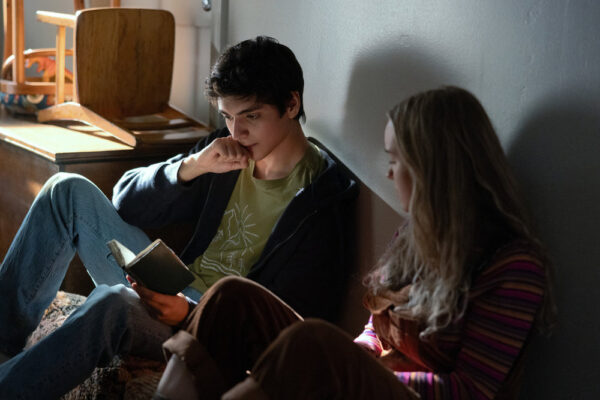 Nicholas (Luciano Leroux) sits next to Meryl (Emilie Bierre) in the hall