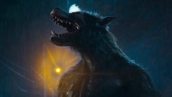 A werewolf howling to the left, with a yellow stoplight behind